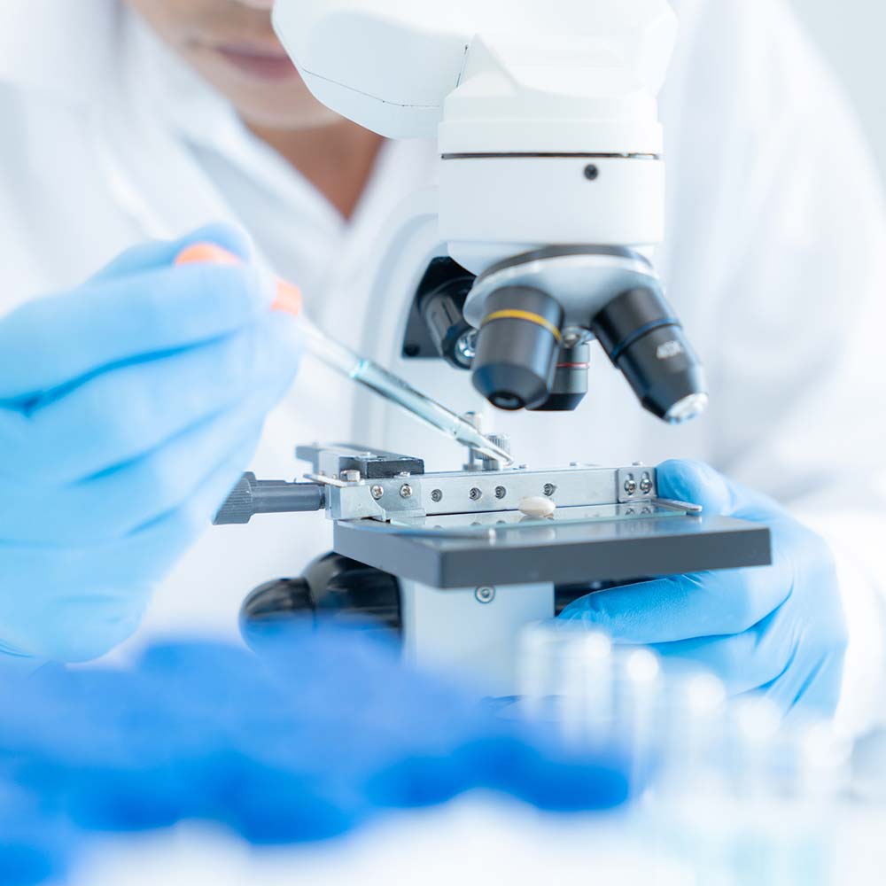 a lab tech using a microscope